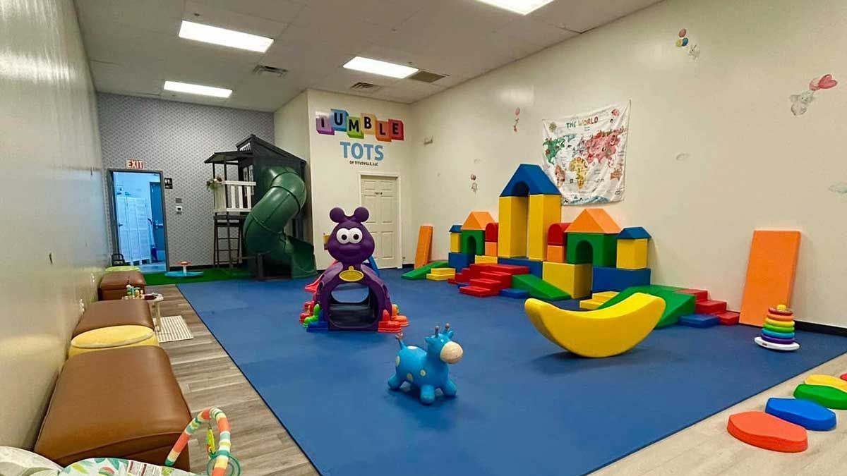 A baby is playing with a toy on the floor.