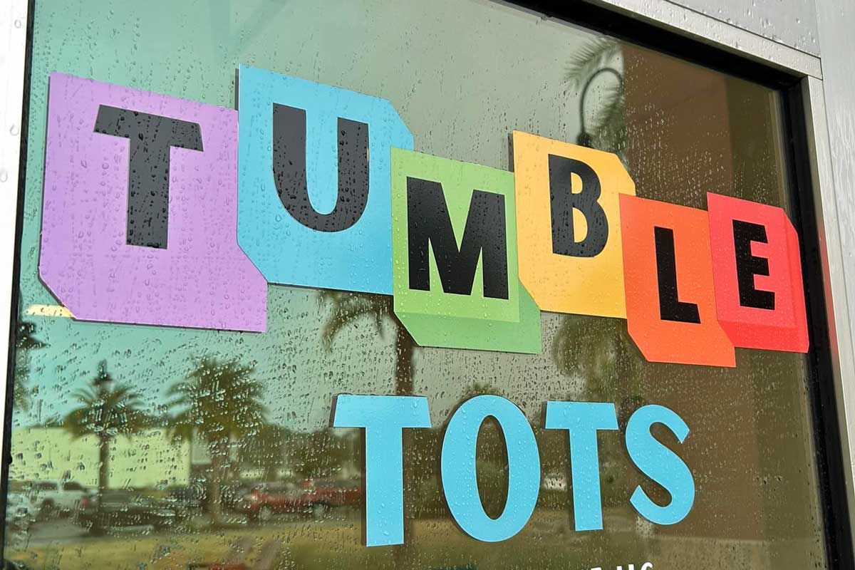 A little girl is sitting at a table with a birthday cake.