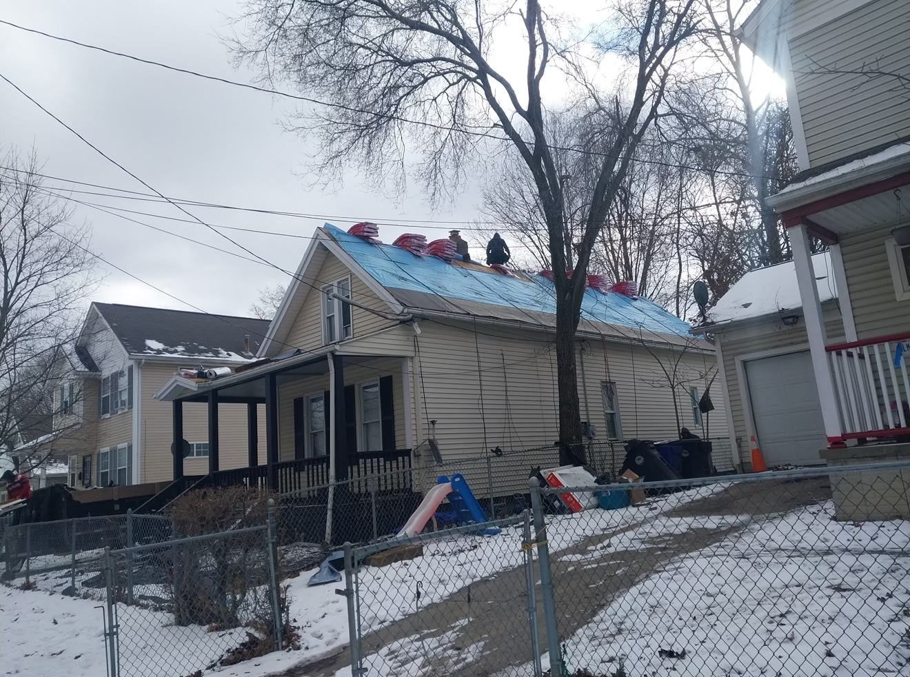A group of people are working on the roof of a house.