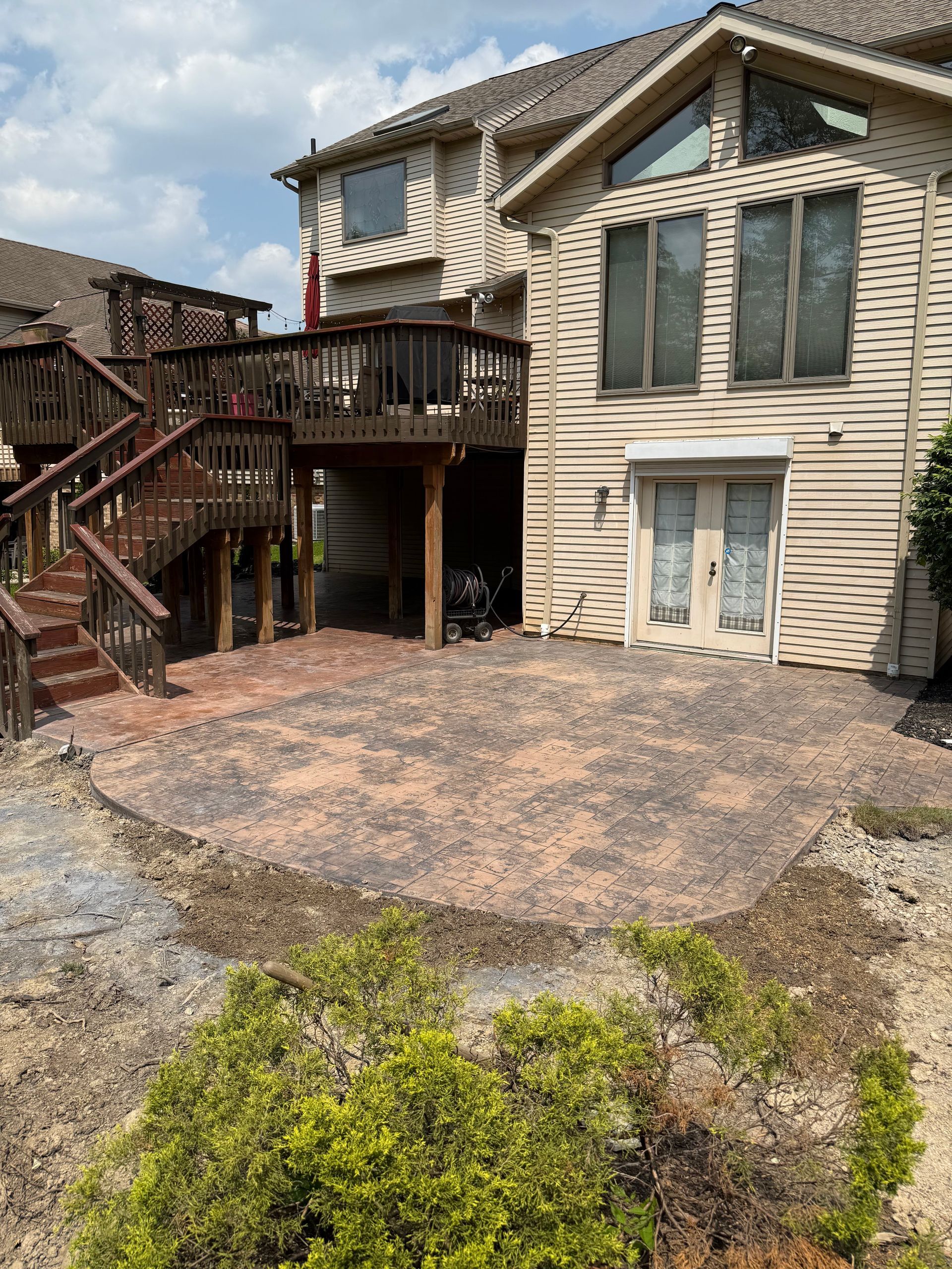 A large house with a deck and stairs in front of it.