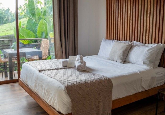 A bedroom with a large bed and a sliding glass door.