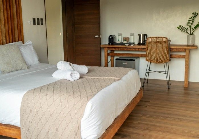 A hotel room with a bed , desk and chair.