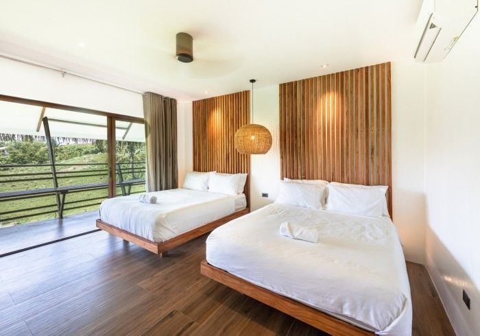 A hotel room with two beds and a large window.