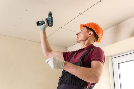 handyman installing a drywall ceiling