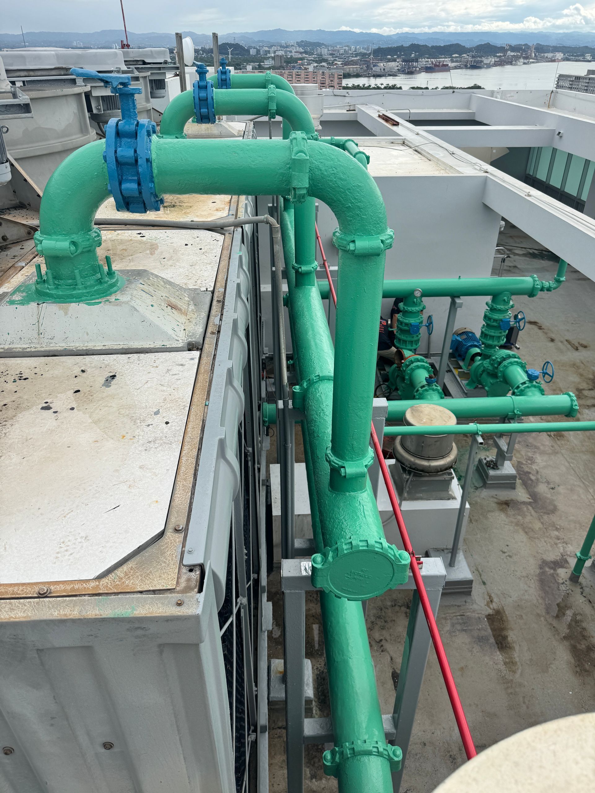 A living room with a couch , chair , coffee table and large windows overlooking the ocean.