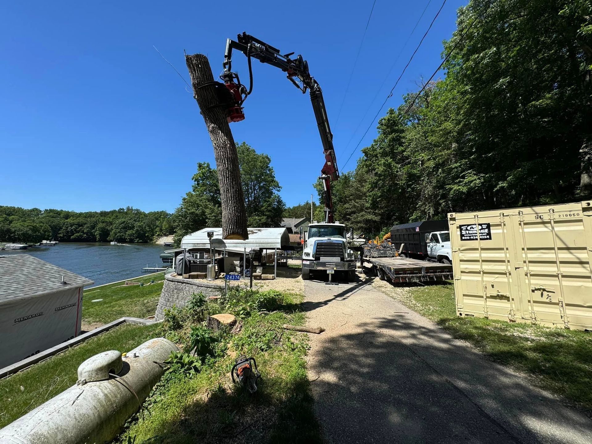 A man is cutting a tree branch with a chainsaw.