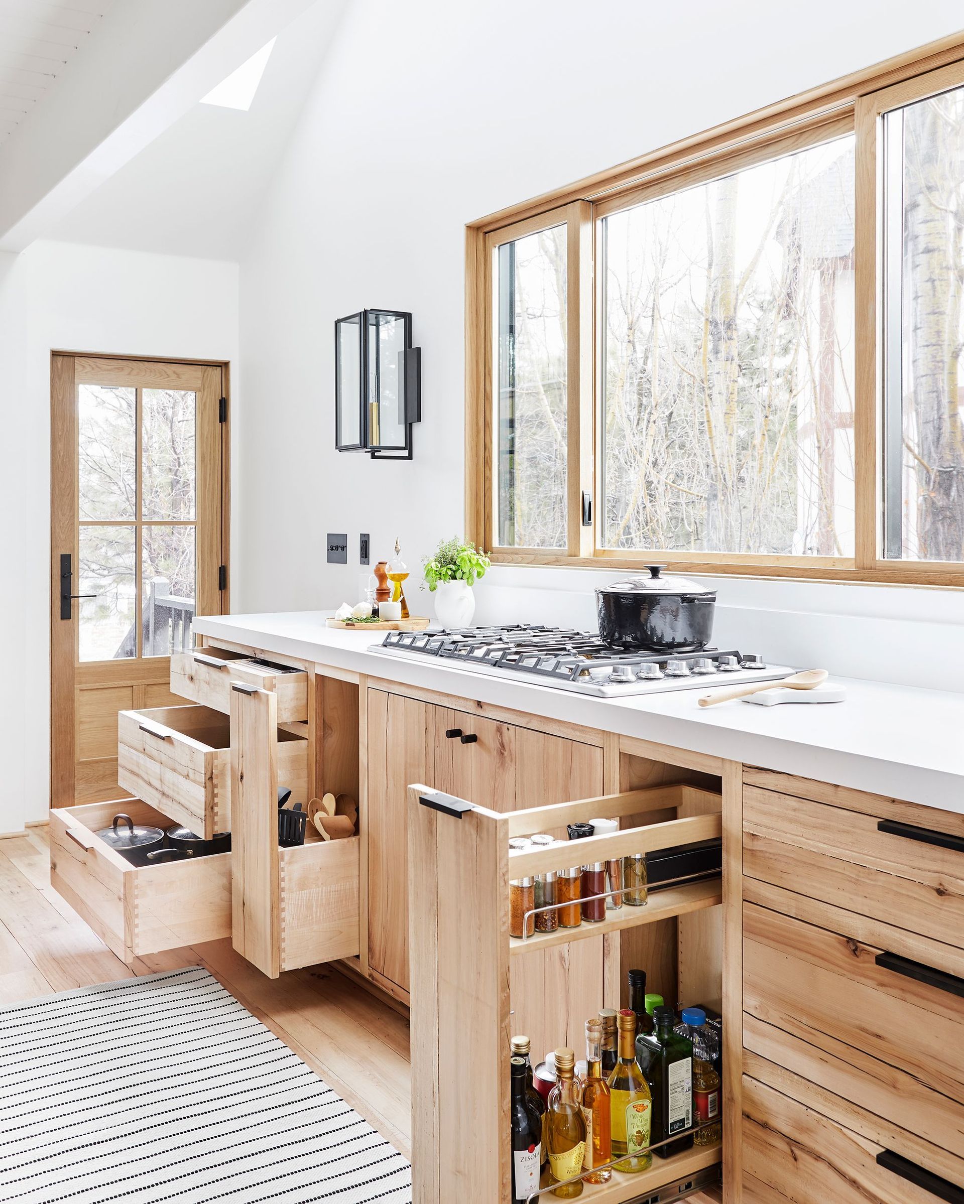 A kitchen with wooden cabinets and drawers and a stove top oven.