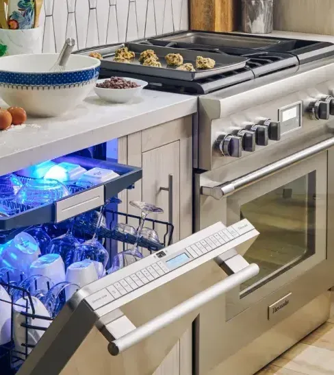 A kitchen with a stove and a dishwasher with the door open