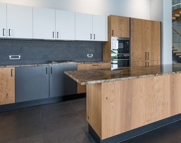 A kitchen with wooden cabinets and a granite counter top.