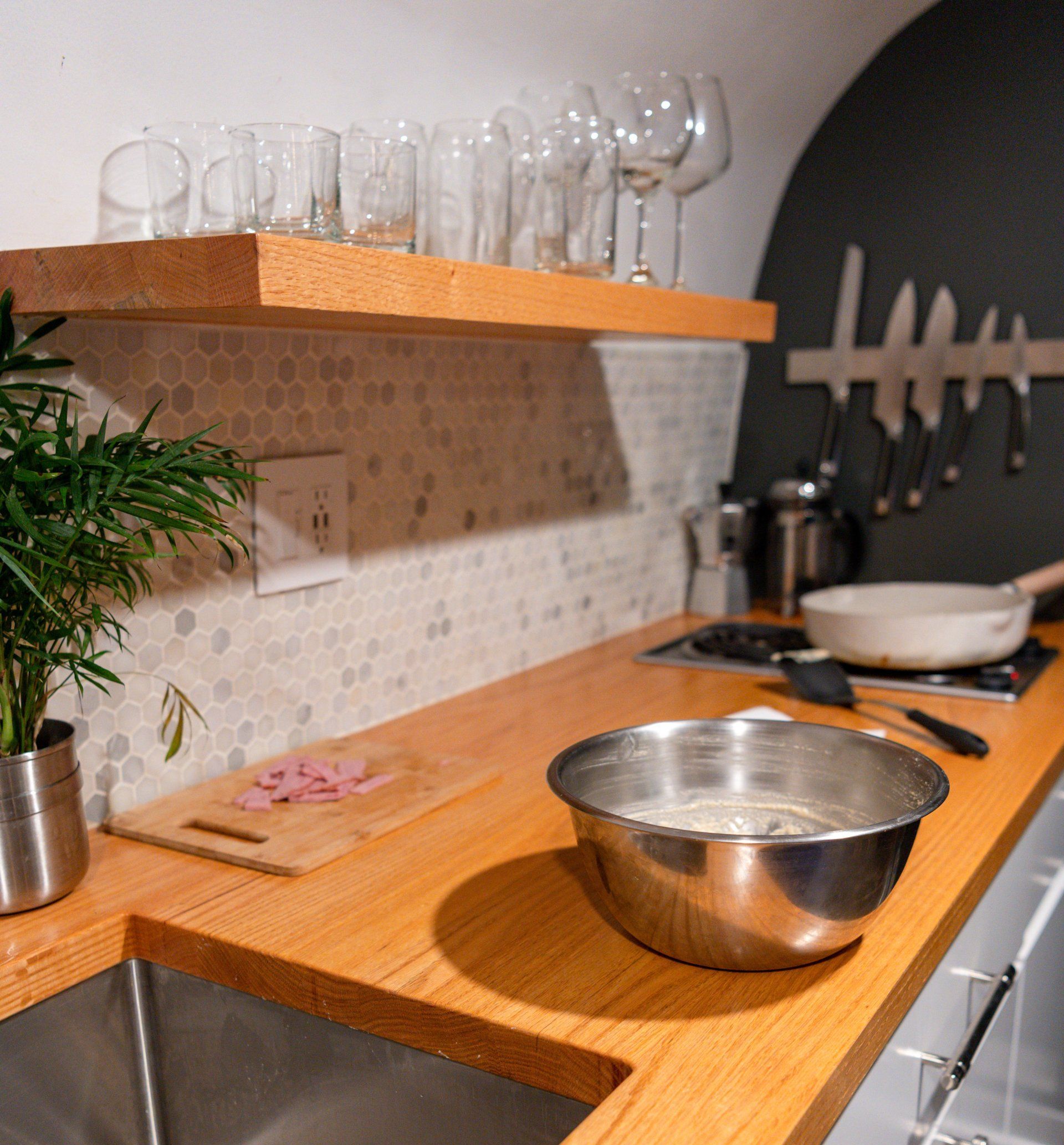 A kitchen counter with a metal bowl on it