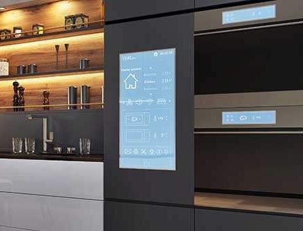 A kitchen with a touchscreen display on the wall.