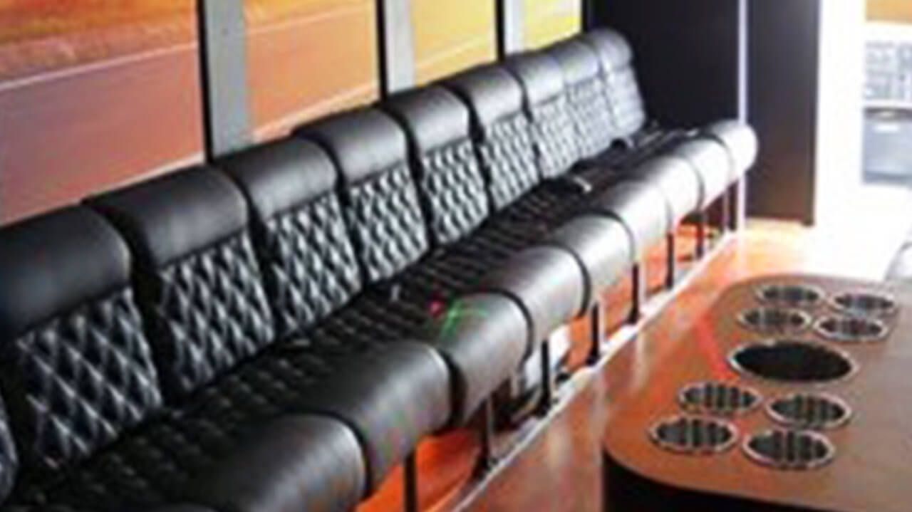 A row of black leather chairs sitting next to each other in a room.