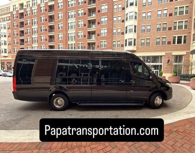 A man in a suit and tie is standing next to a car.