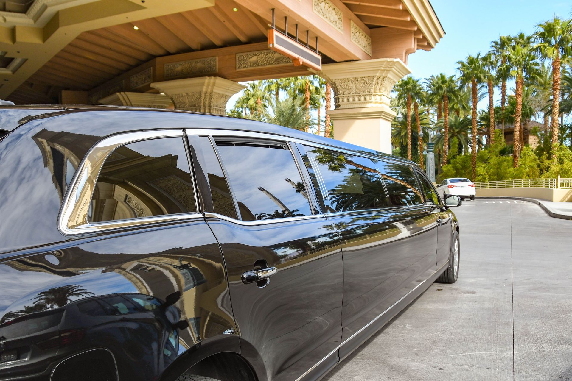 A black limousine is parked in front of a building