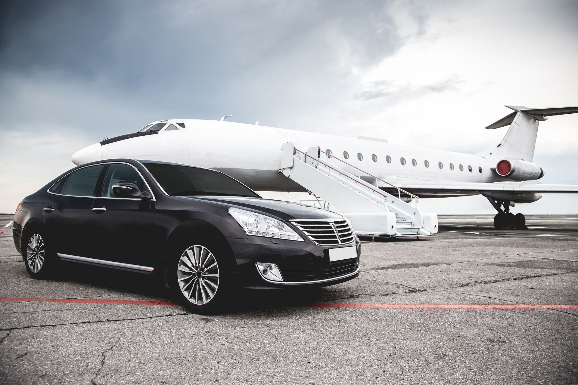 A car is parked in front of a private jet.