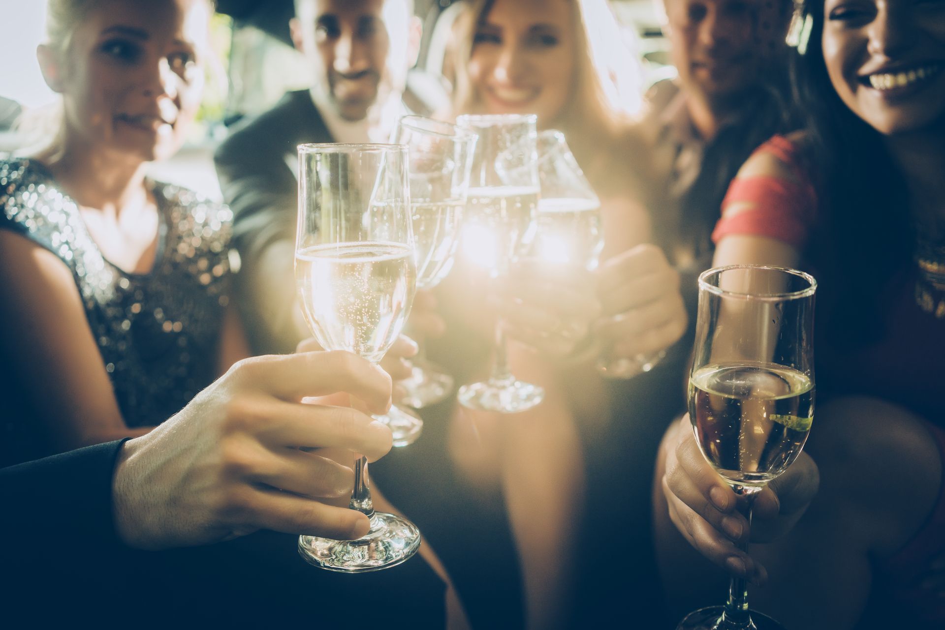 A group of people are toasting with champagne glasses at a party.