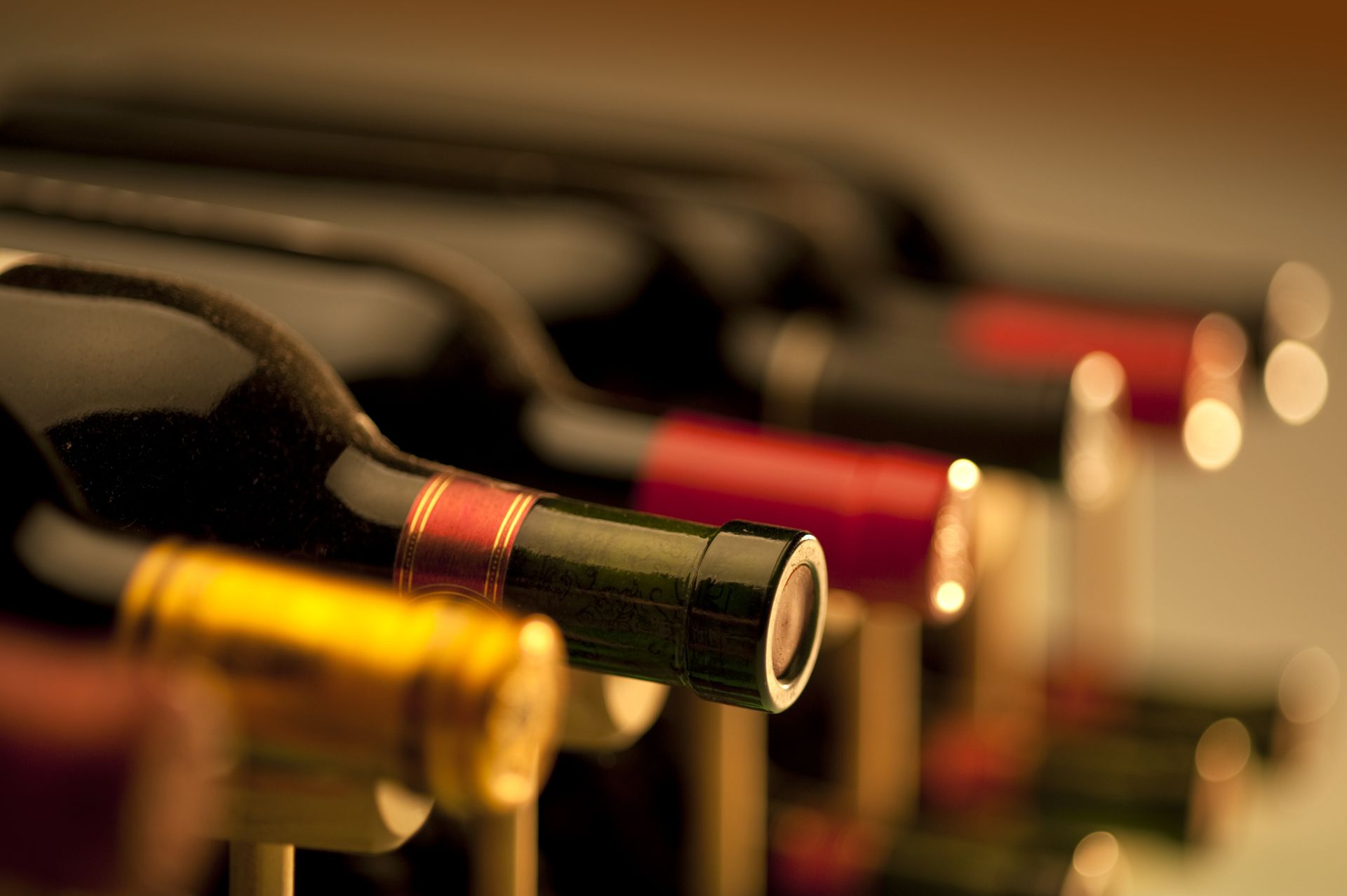 A row of wine bottles sitting on top of each other on a shelf.