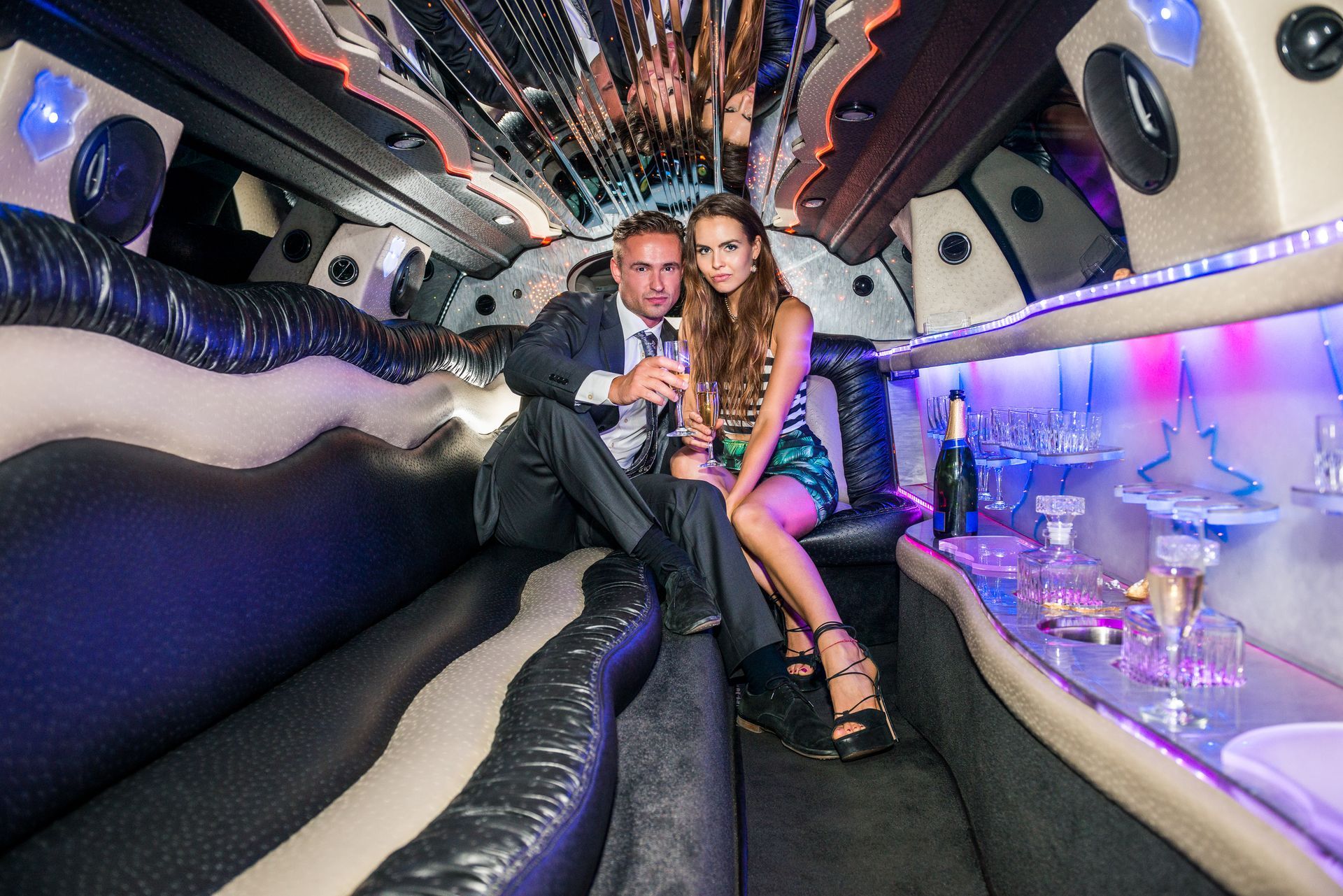 A man and a woman are sitting in a limousine.