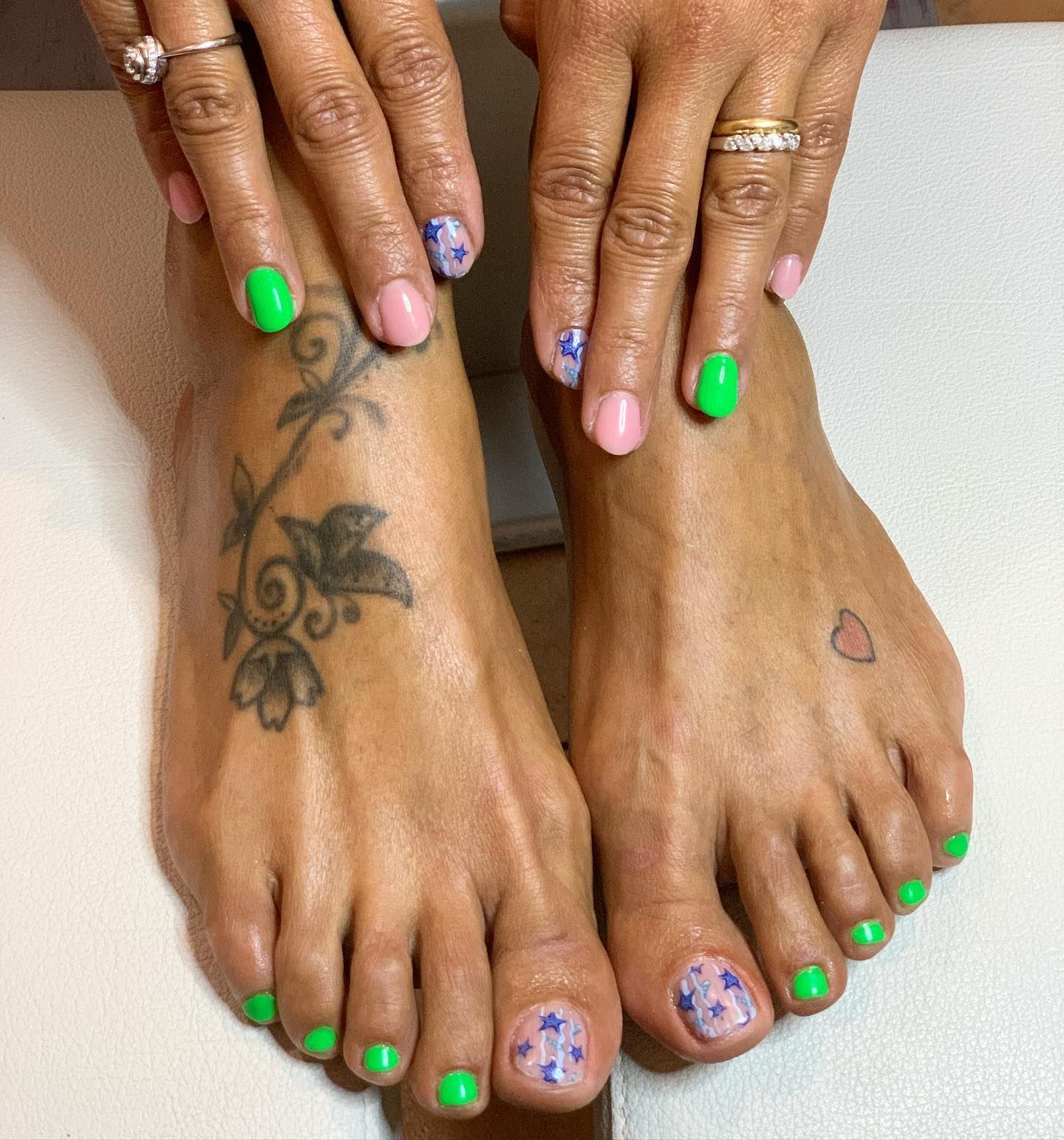 Una donna con le unghie verdi e un tatuaggio sul piede
