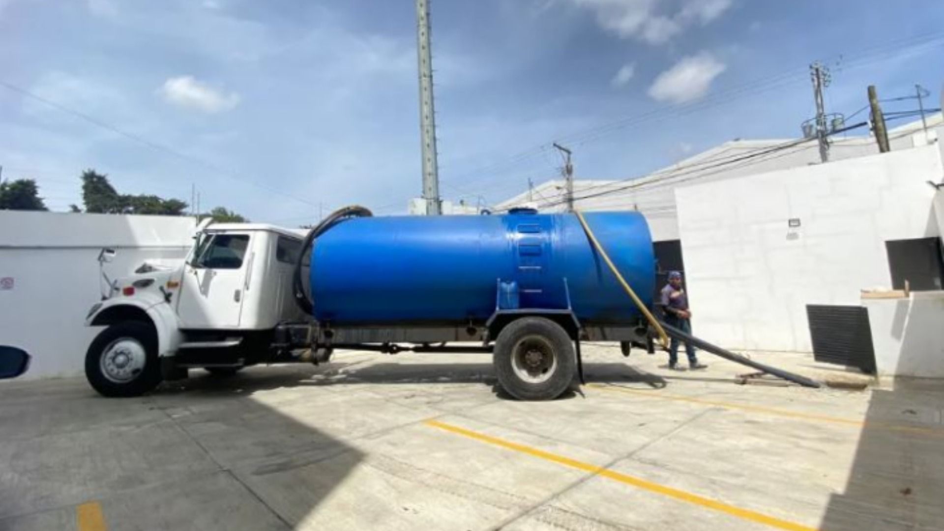 Un camión azul y blanco está estacionado en un estacionamiento.