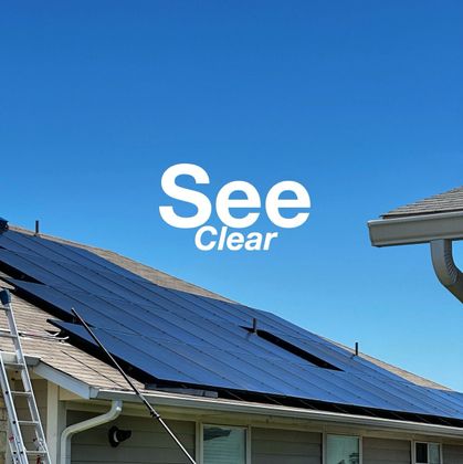 Solar panels on a shingled roof under a bright blue sky, with the text 