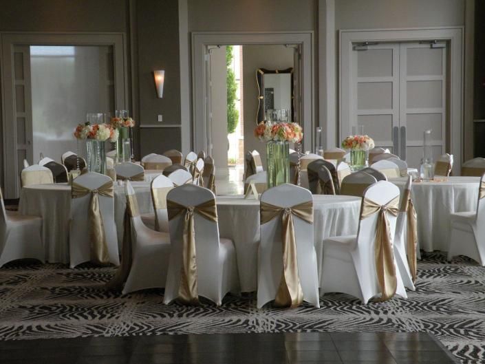 Round banquet tables set for an elegant event in a beige dining room