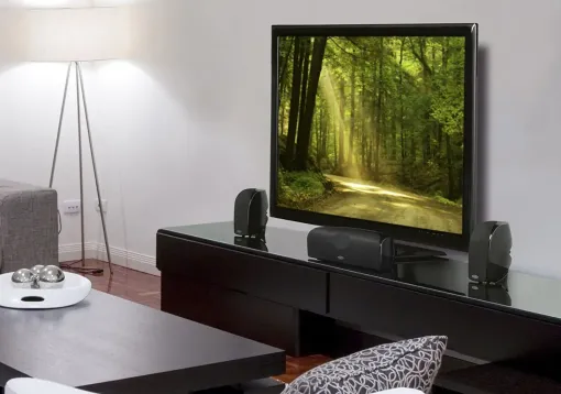 Person holding tablet displaying live feeds from several security cameras inside a home.