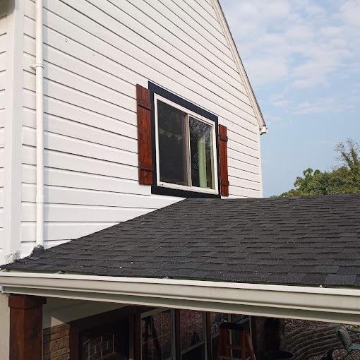 A white house with a black roof and a window