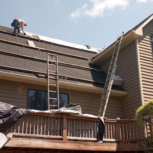 A man is working on the roof of a house.