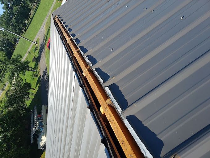 An aerial view of a metal roof with a wooden gutter