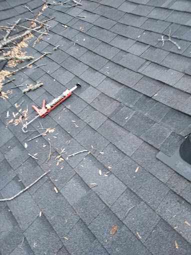 A roof with shingles and a tool on it.
