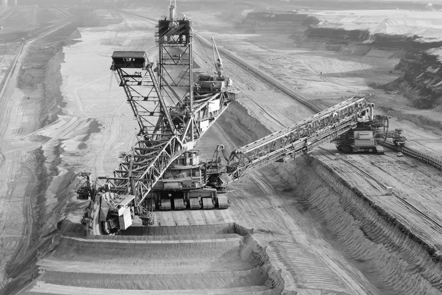 Ein Schwarzweissfoto eines grossen Baggers in einem Bergwerk.