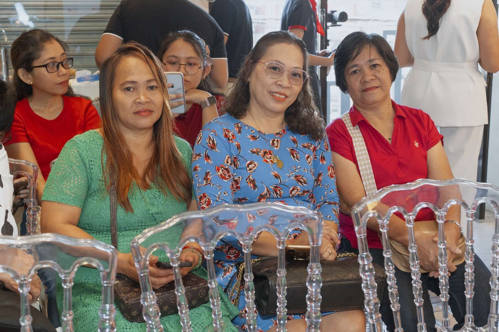 A group of women are sitting in clear chairs.