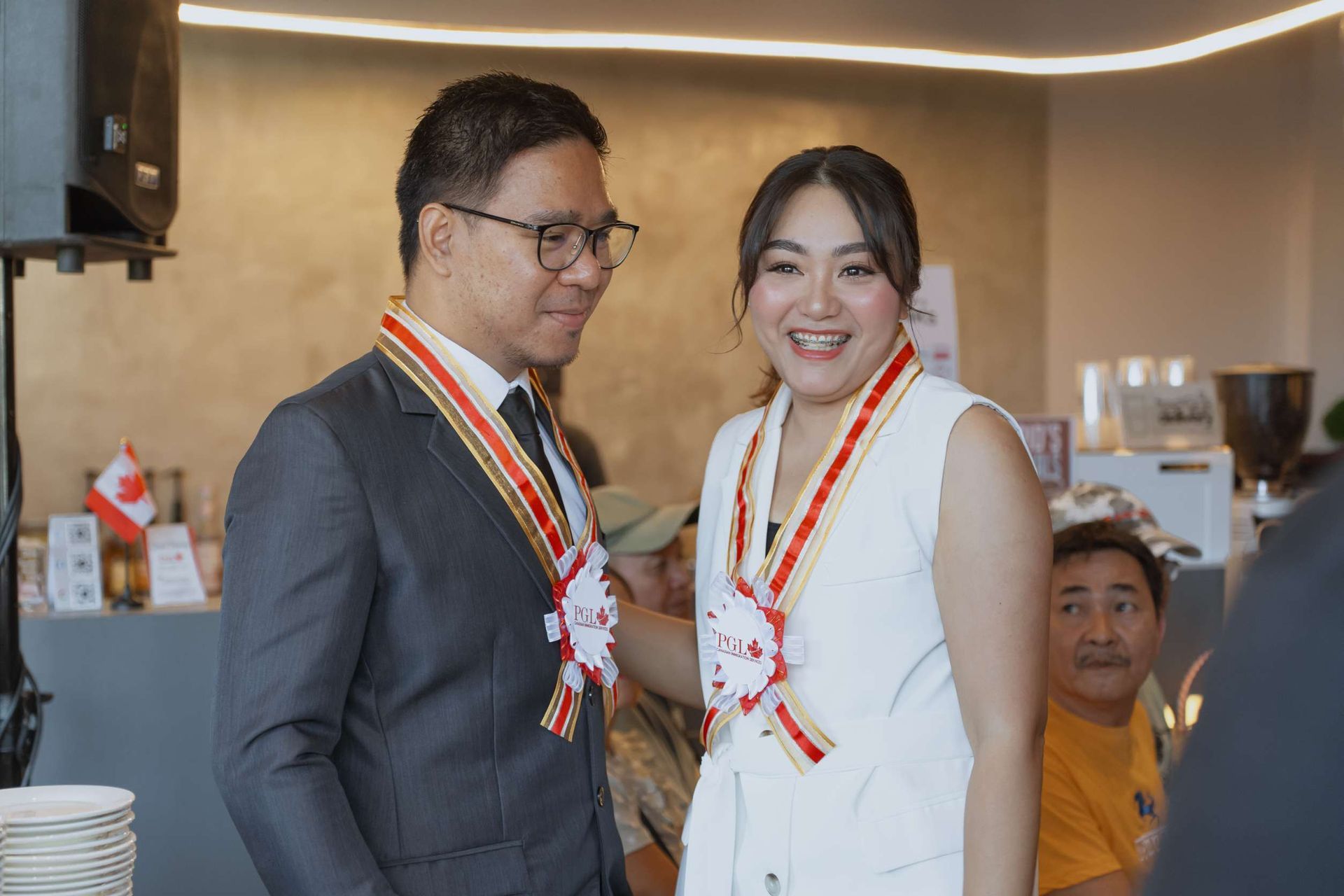 A man and a woman are standing next to each other wearing medals.