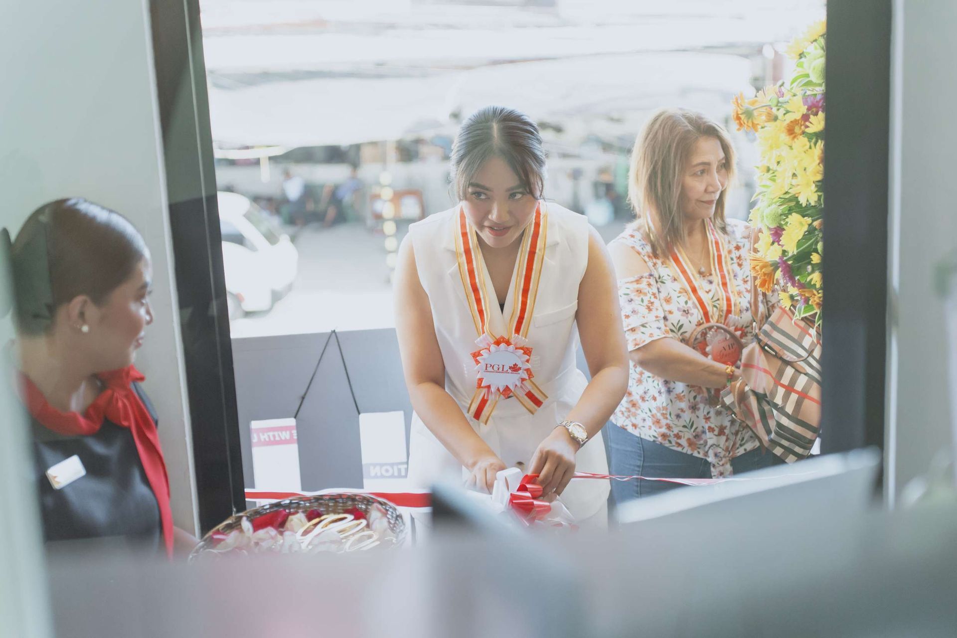 A group of women are standing in front of a window.