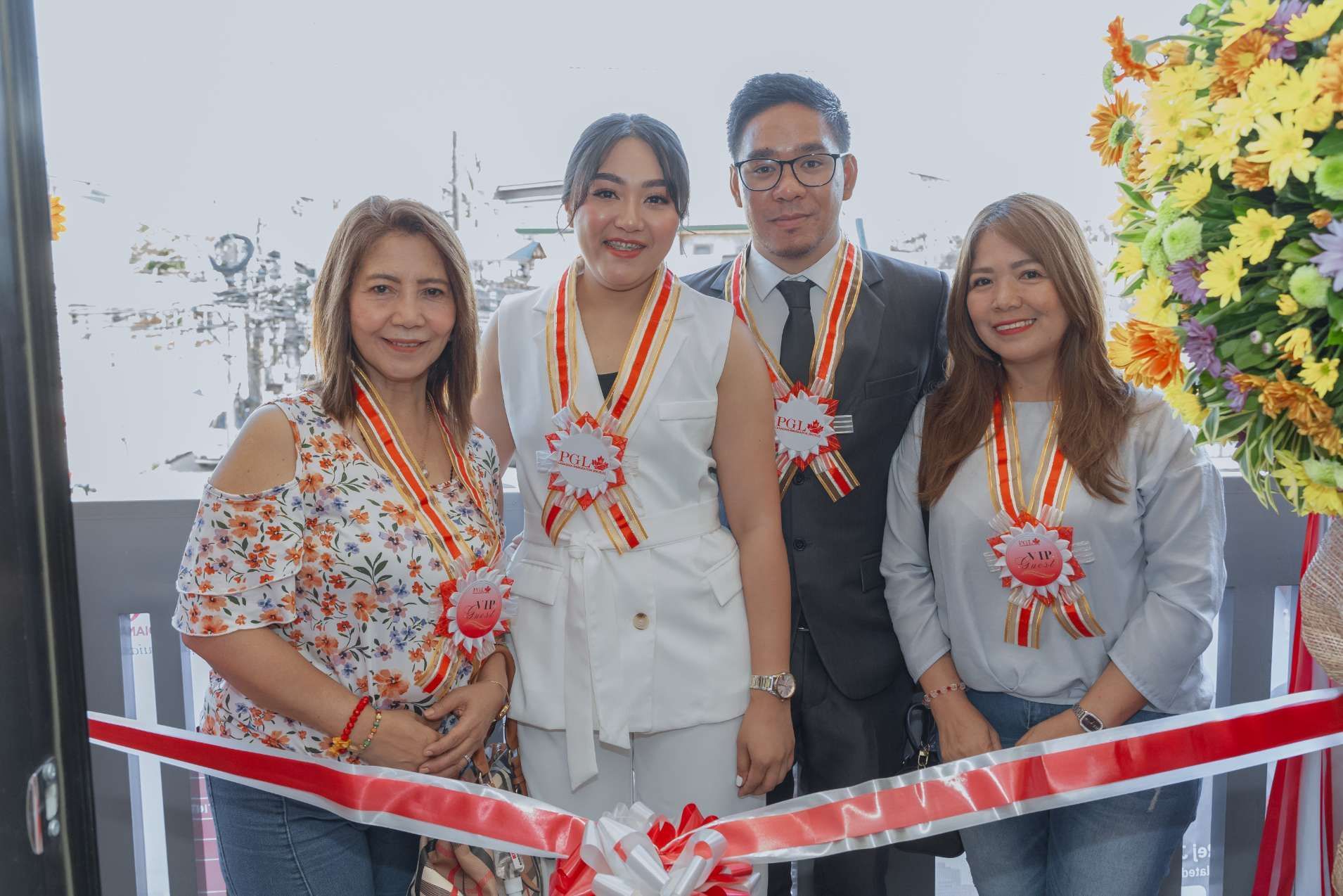 A group of people are standing next to each other in front of a ribbon.