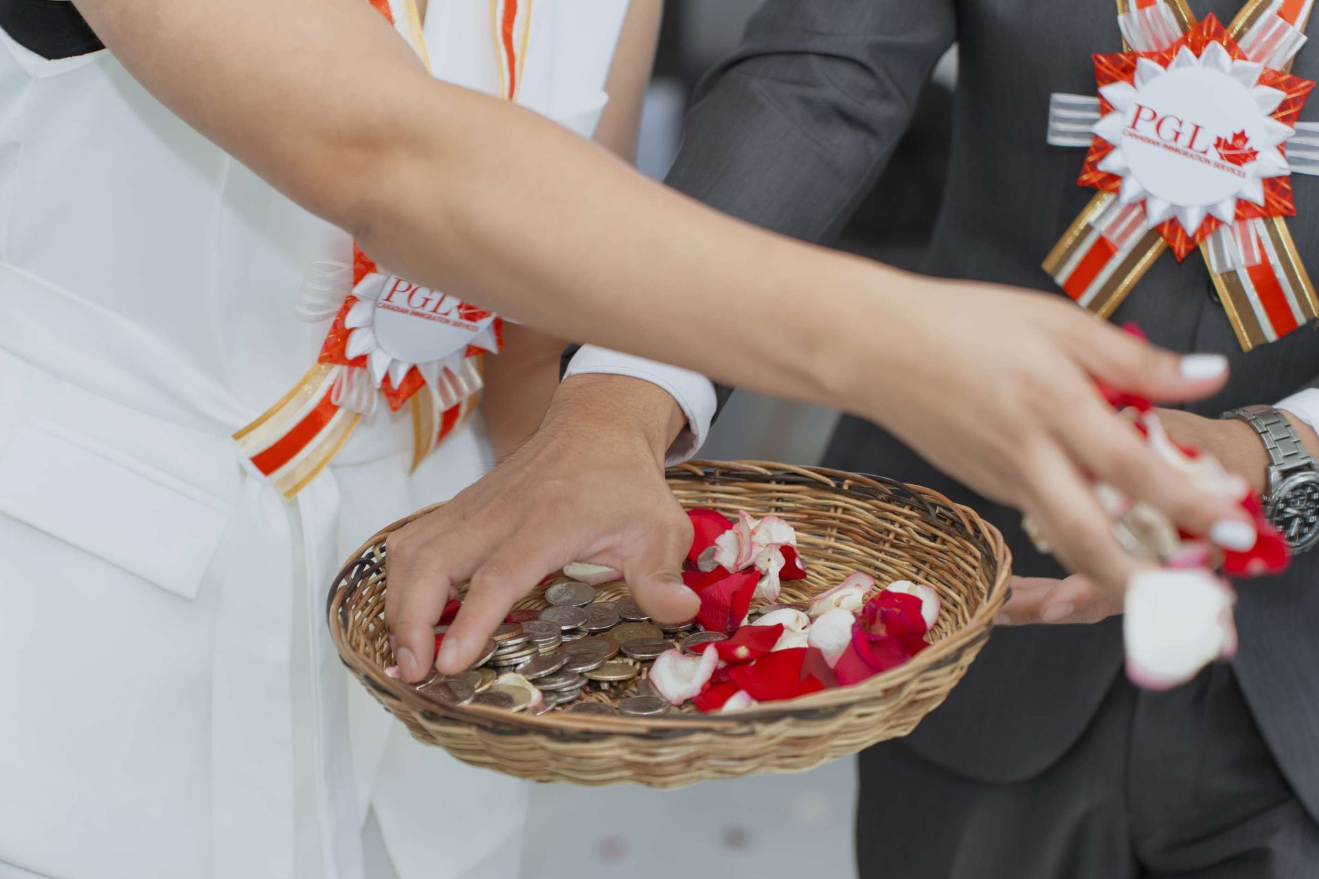 A bride and groom are holding a basket of rose petals