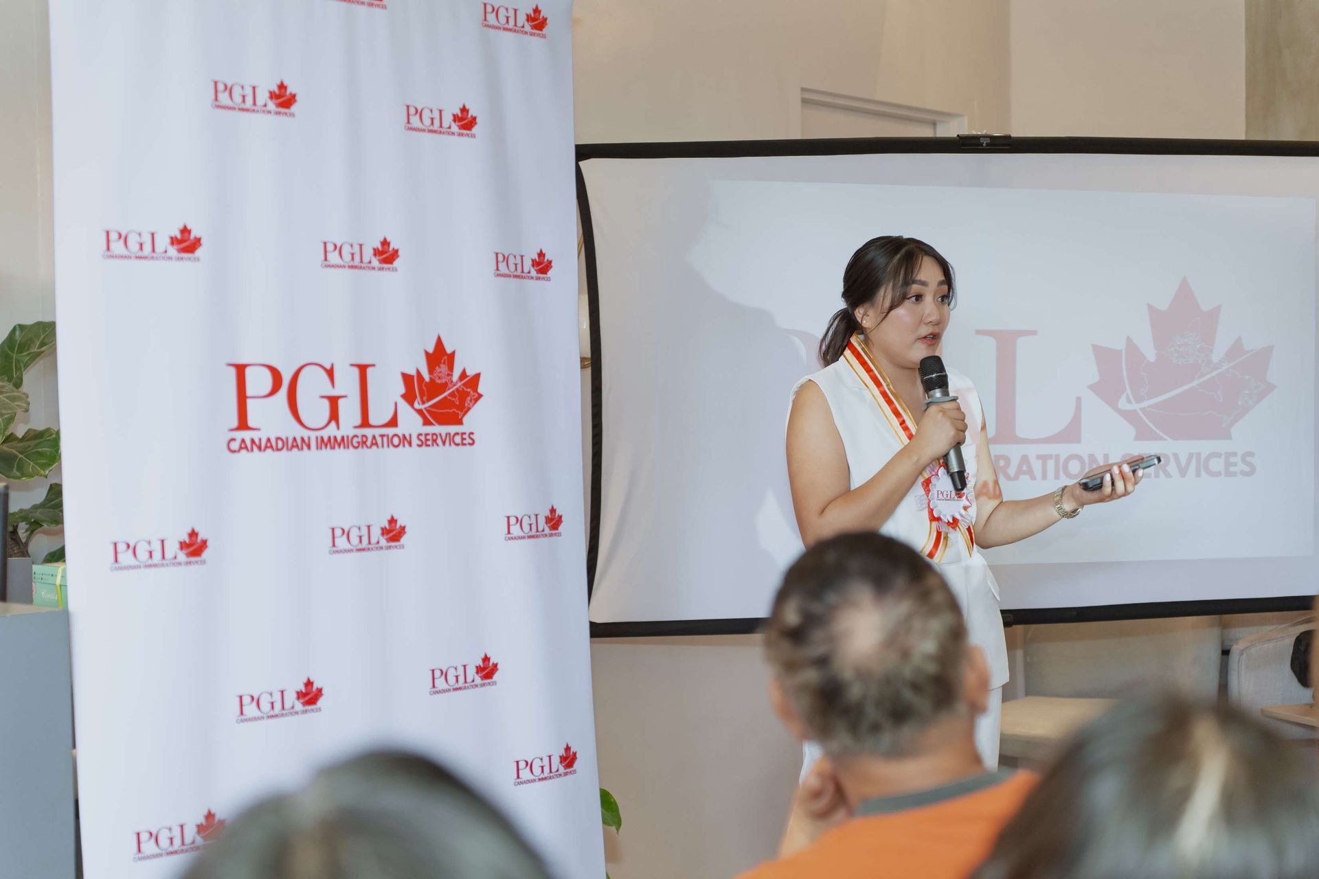 A woman is giving a presentation in front of a group of people.