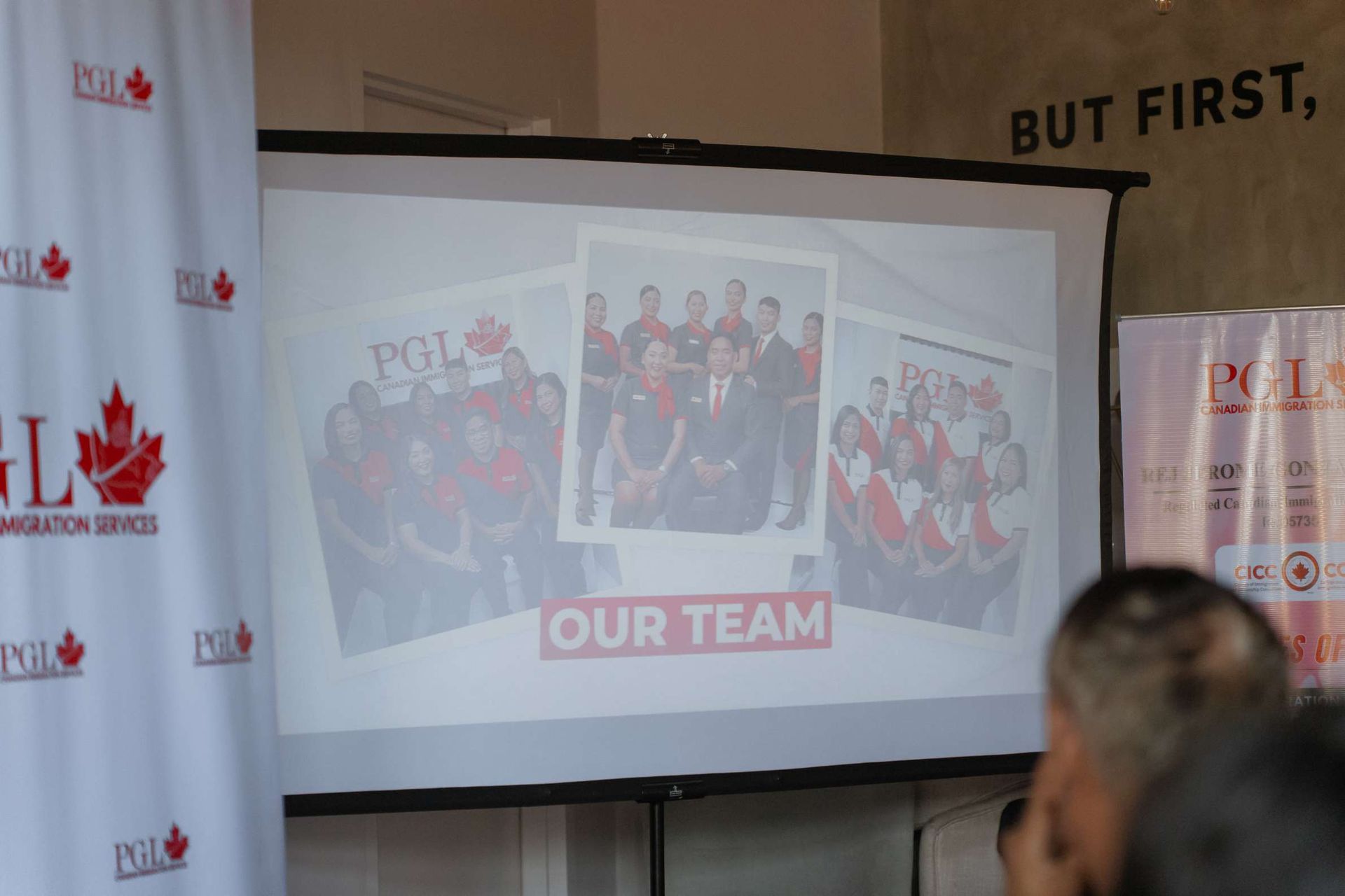 A man is looking at a projector screen with a picture of a group of people on it.