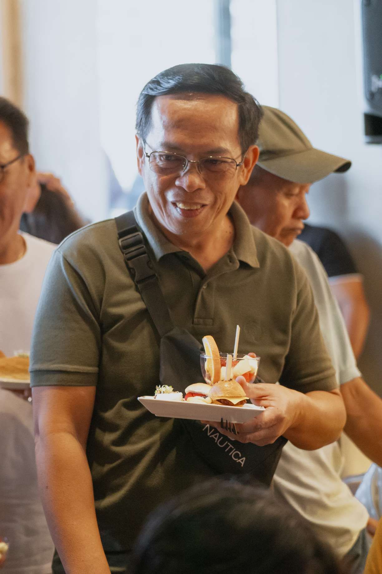 A man is holding a plate of food in his hand.