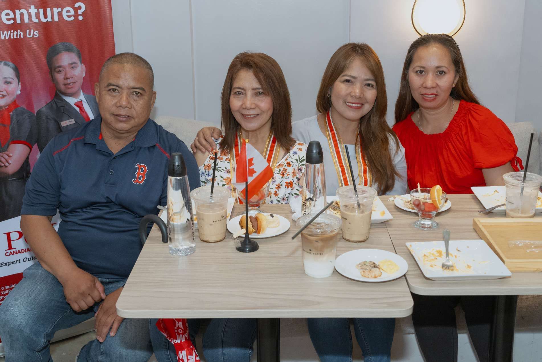 A group of people are sitting at a table with plates of food.