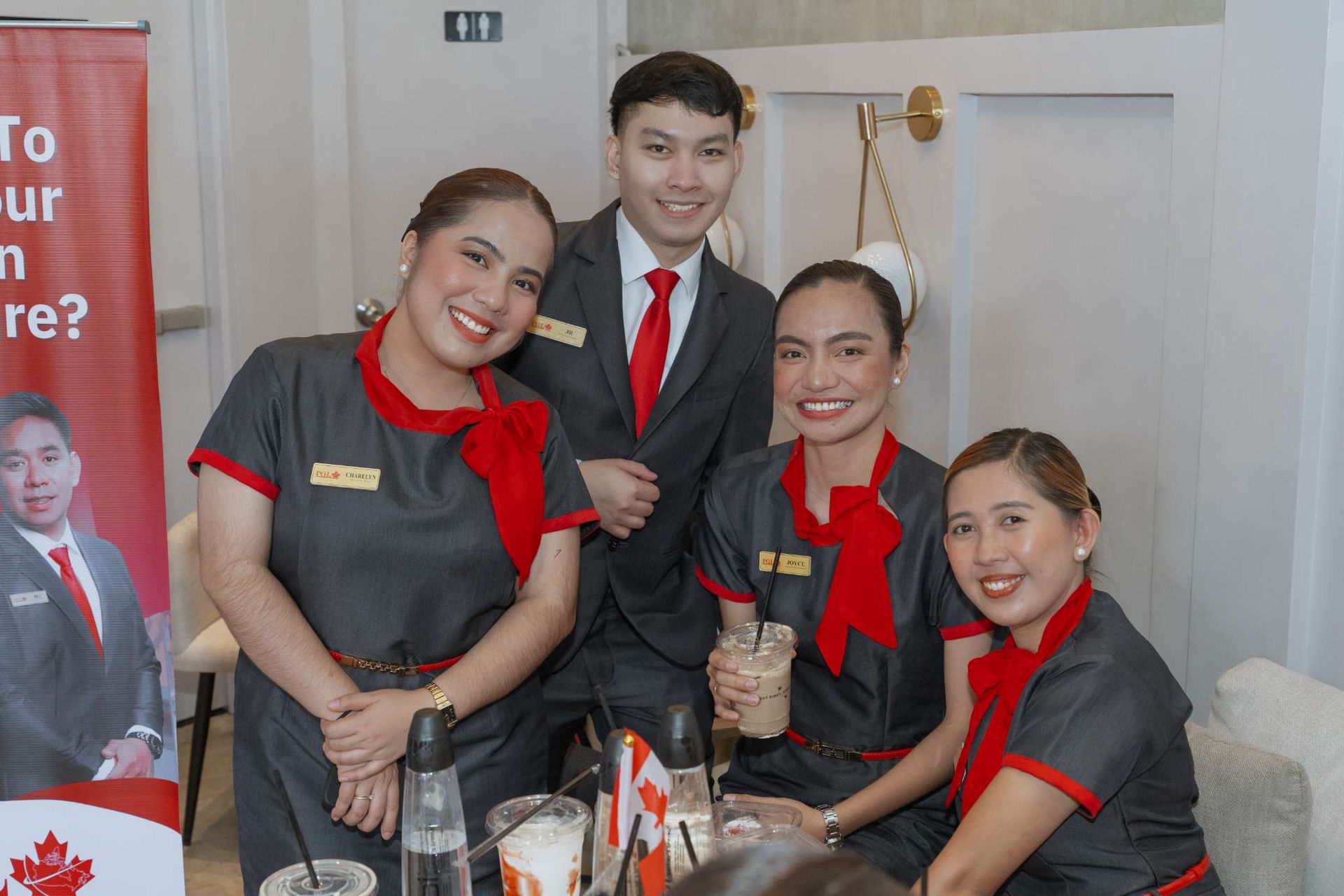 A group of people are posing for a picture while sitting at a table.