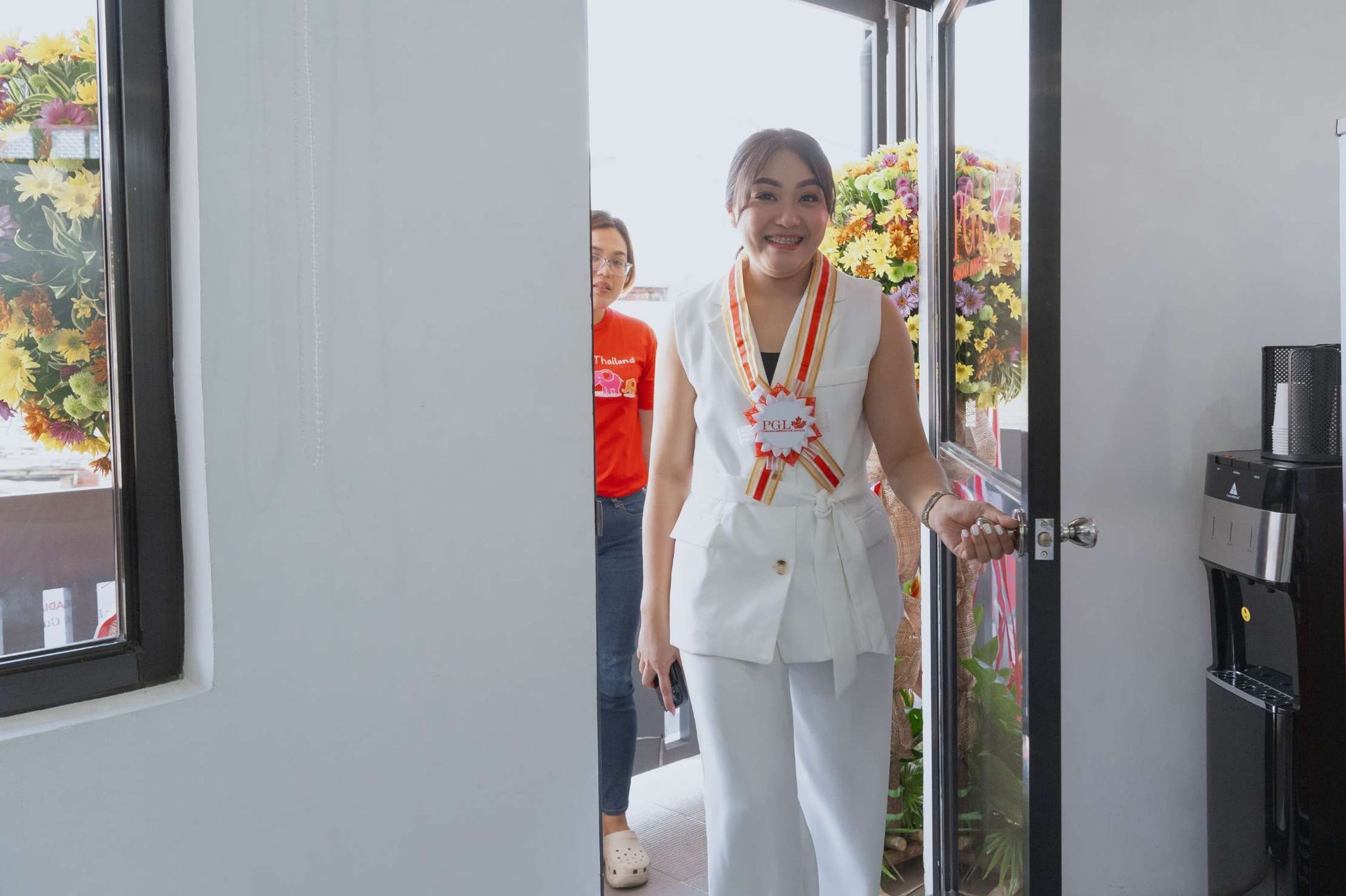 A woman is walking through a doorway in a room.