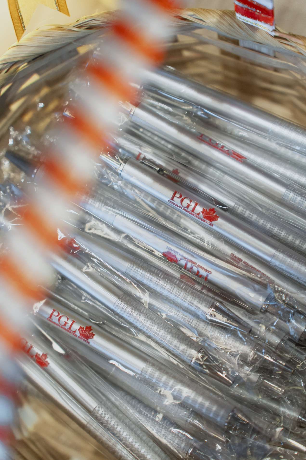 A bunch of pens are wrapped in plastic in a basket.
