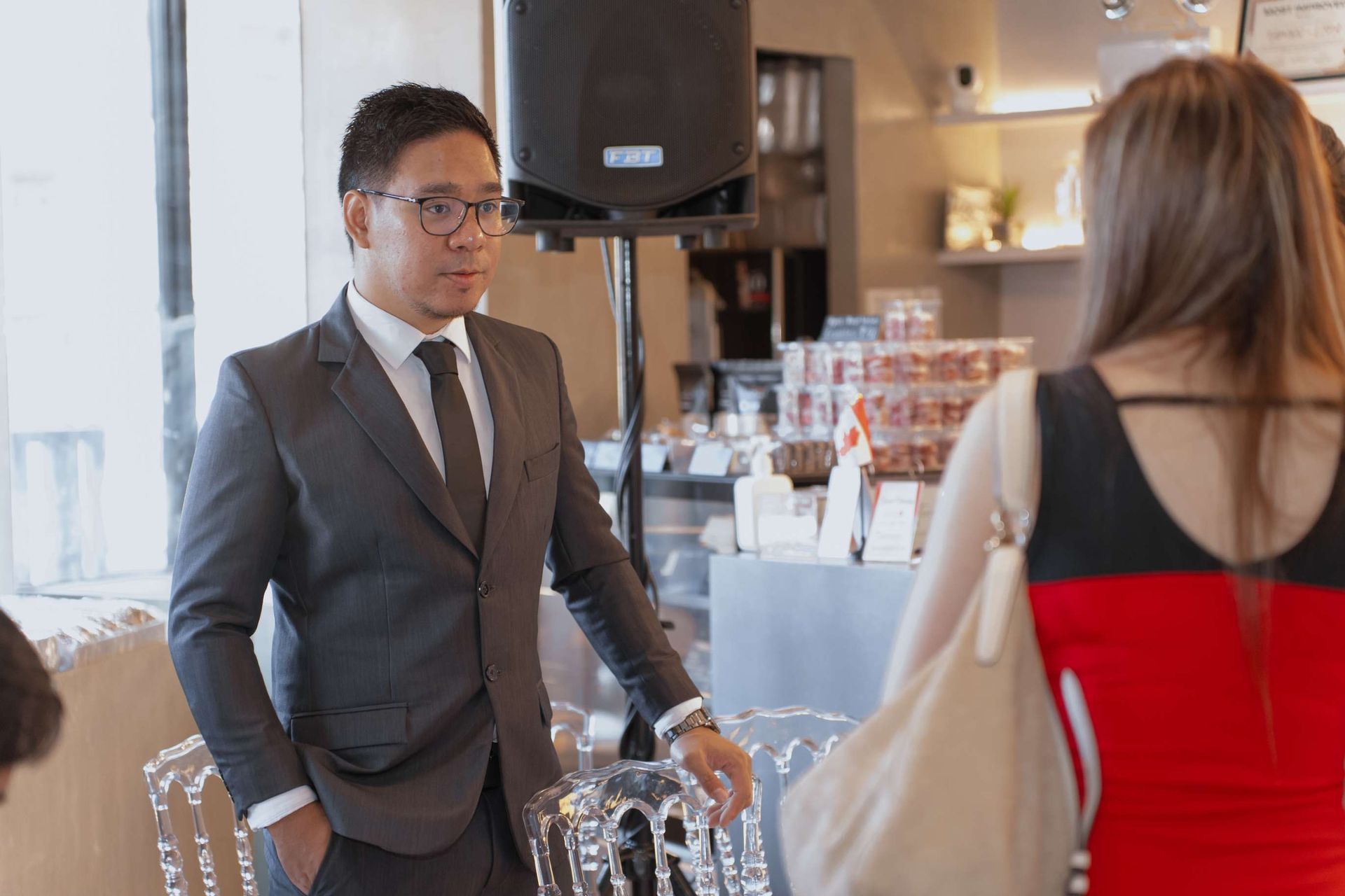 A man in a suit and tie is talking to a woman in a red dress.