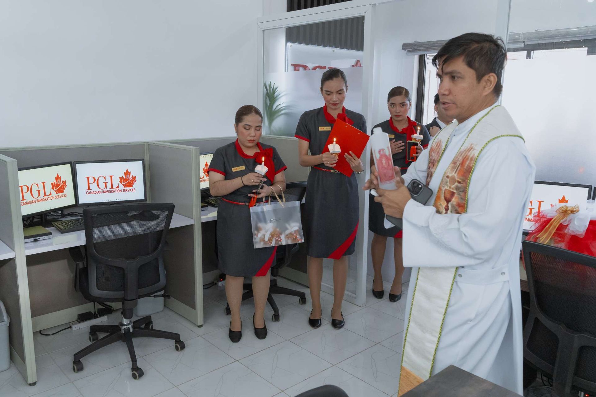 A woman is standing in front of a window holding a pair of scissors.