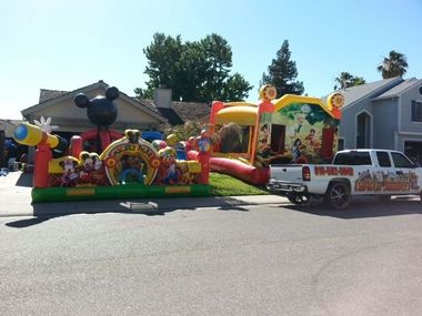 A large inflatable bouncy house is sitting in front of a blue sky.