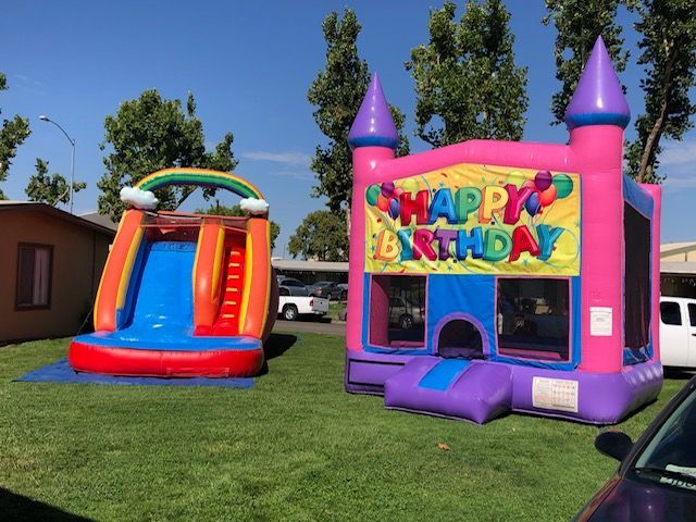 A pink bouncy house with the words happy birthday on it