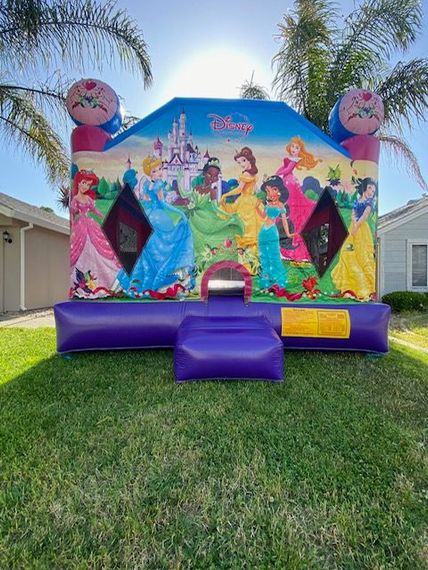 A happy child is playing on the inflatable house.