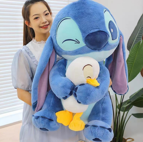 Un peluche de Stitch azul abraza a un peluche de pato blanco en una habitación infantil iluminada por el sol, cerca de una cuna de madera.